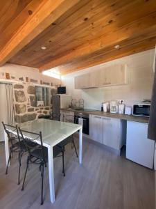 a kitchen with a table and chairs in a room at La maison D'Orée in Polignac