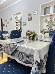 a dining room table with blue chairs and a table cloth at Marvarid INN in Samarkand