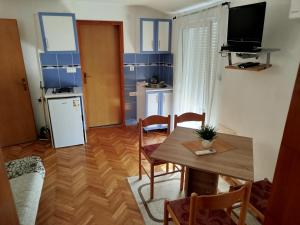 a living room with a table and a small kitchen at MARINOVIC APARTMENTS in Budva