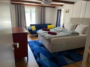 a bedroom with a bed and a blue couch at Avenue 15 Boudry Suites and Studio in Boudry