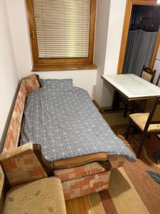 Ein Bett stand in der Ecke eines Zimmers mit einem Tisch. in der Unterkunft Travnik apartment in Travnik