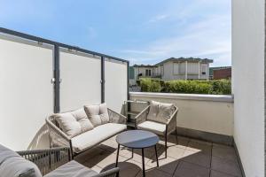 a balcony with a couch and two chairs and a table at Cozy Apartment Central Kitchen Balcony in Frechen