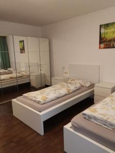 two beds in a room with mirrors at Monteurwohnung Hoffmann in Heilbronn