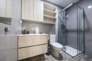 a bathroom with a sink and a toilet and a shower at Apartamentos e quartos Primorosa in Nazaré +63 photos