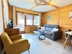 a living room with a couch and a table at Apparement cosy 4 personnes in Samoëns