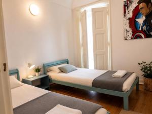 a room with two beds and a painting on the wall at Casa de Sta Clara in Évora