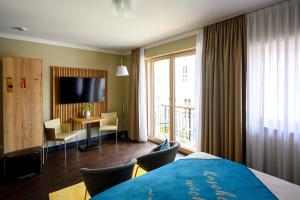 a hotel room with a bed and a table with chairs at THE GREEN Rostock Apartment Hotel in Rostock