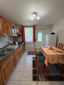 a kitchen with a table and a kitchen with a refrigerator at Flóra Apartmanok in Parádsasvár