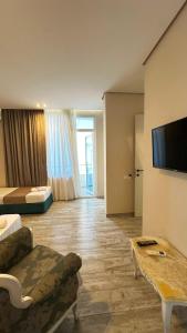 a living room with a couch and a flat screen tv at National Lux in Ureki