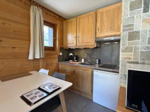 a kitchen with wooden cabinets and a counter top at Apparement cosy 4 personnes in Samoëns