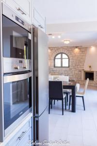 a kitchen with a stainless steel refrigerator and a dining room at Kalami Sunlight Villa in Kalami