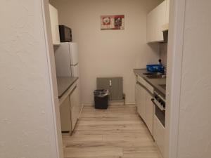 a kitchen with white cabinets and a wooden floor at Monteurwohnung Hoffmann in Heilbronn