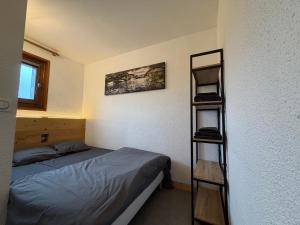 a bedroom with a bed and a book shelf at Apparement cosy 4 personnes in Samoëns