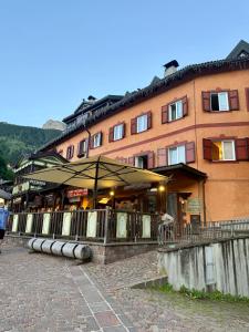 a large building with an umbrella in front of it at Maison Moena Dolomites in Moena