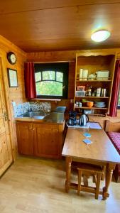 a kitchen with a wooden table in a room at La Dorépontaise ROULOTTE in Pondaurat
