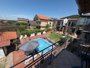 a balcony with a swimming pool and an umbrella at Serenity Hill-Bulharsko U Nás in Sveti Vlas