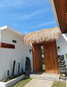 a door to a building with a straw roof at Alaksa villa padang padang 6 in Bingin Beach