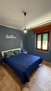 a bedroom with a blue bed and a window at RaJan Home Blue in Palizzi Marina