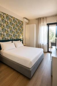 a bedroom with a large white bed and a window at Hotel Salus in Pescara