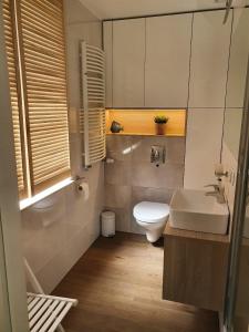 a bathroom with a white toilet and a sink at Dormare in Grzybowo