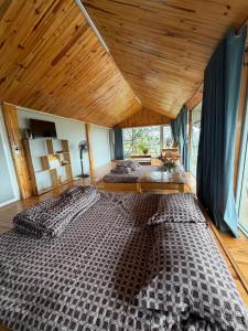 two beds in a bedroom with a wooden ceiling at Vườn của mẹ in Da Lat