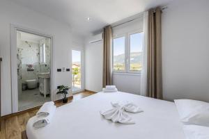 a bedroom with a white bed with a large mirror at Bliss by PikHost in Gjirokastër