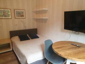 a small room with a bed and a table and a television at Dormare in Grzybowo
