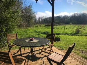 a table and two chairs on a wooden deck at La Dorépontaise ROULOTTE in Pondaurat +36 photos