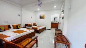 a room with two beds and two chairs in it at Victory Villa Sigiriya in Sigiriya +143 photos