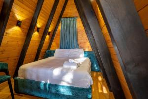 a bedroom with a bed in a room with wooden walls at Golden Cabins Gjinar by PikHost in Elbasan
