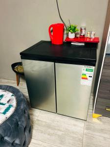a small refrigerator with a black top in a room at Lake boutique hotel empire in Thohoyandou