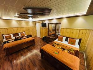 a large room with two beds and a television at Himawari Hills Hotel and Hostel in Nuwara Eliya