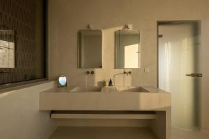 a bathroom with two sinks and two mirrors at CAPO LEFKADA Villa 71 - Sea View - Two Private Pools in Tsoukalades