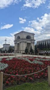 a building with a bunch of flowers in a park at Cathedral Park Smart Apartment in Chişinău