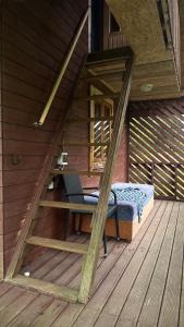 a bed and a chair on a wooden deck at Ziedi in Ieriķi