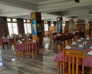 a dining room with tables and chairs with purple table cloth at Hotel Mashabrum Skardu Free Breakfast Mountain View Family Rooms & Free WiFi in Skardu
