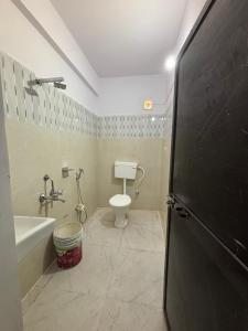 a bathroom with a toilet and a tub and a sink at Yashoda Inn in Ormānjhi