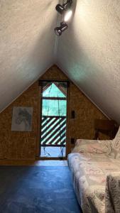 a attic room with a bed and a window at Ziedi in Ieriķi