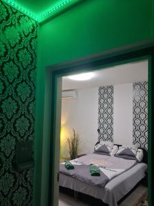 a green room with a bed and a mirror at Zöld otthon in Szeged