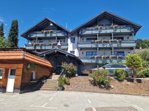 a building with a car parked in front of it at Pension Landhaus Koller - Adults only in Bodenmais