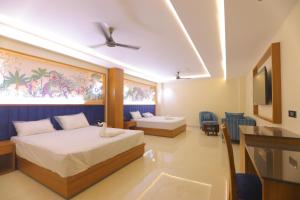 a hotel room with two beds and a tv at Chunmun Elite Retreat in Bulandshahr