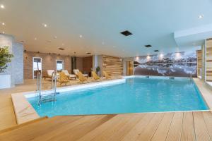 a swimming pool in a hotel with a table and chairs at Horizont Aparthotel Jahorina in Jahorina
