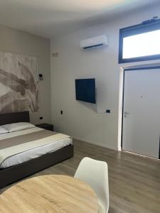 a bedroom with a bed and a table and a tv at Villa Uma con Idromassaggio e Parcheggio Privato in Sannicandro Garganico