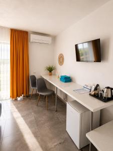 an office with a desk with chairs and a tv on the wall at Danube Delta View in Dunavăţu de Jos