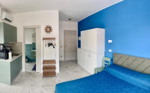 a blue bedroom with a bed and a kitchen at Casa di Bea 2 in Ventimiglia