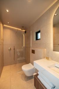 a bathroom with a toilet and a shower and a sink at North Mountain View Suites in Akureyri +51 photos