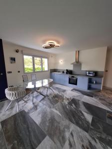 a living room with a table and a kitchen at Suite Romantique in Saint-Romans