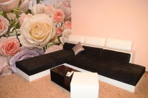 a black couch in front of a bouquet of roses at Hotel Palma in Burgas