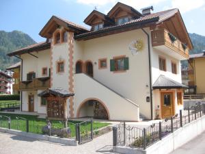 a large house with a fence in front of it at Affittacamere Villa Sole in Fiera di Primiero