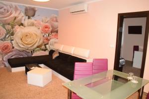 a living room with a couch and flowers on the wall at Palma in Burgas City